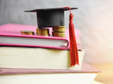 Picture of graduation cap over a stack of books