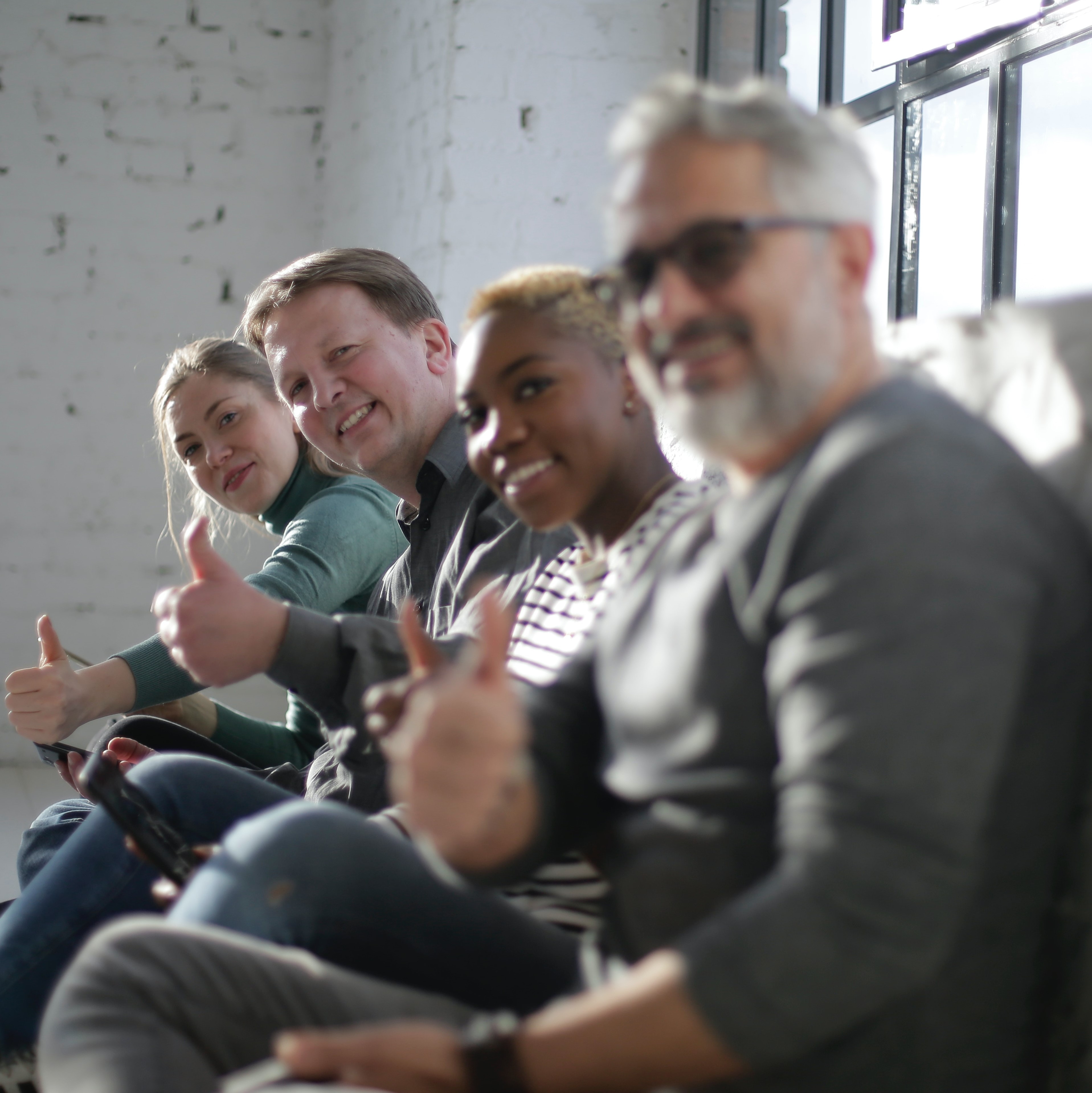 Four people looking at camera smiling